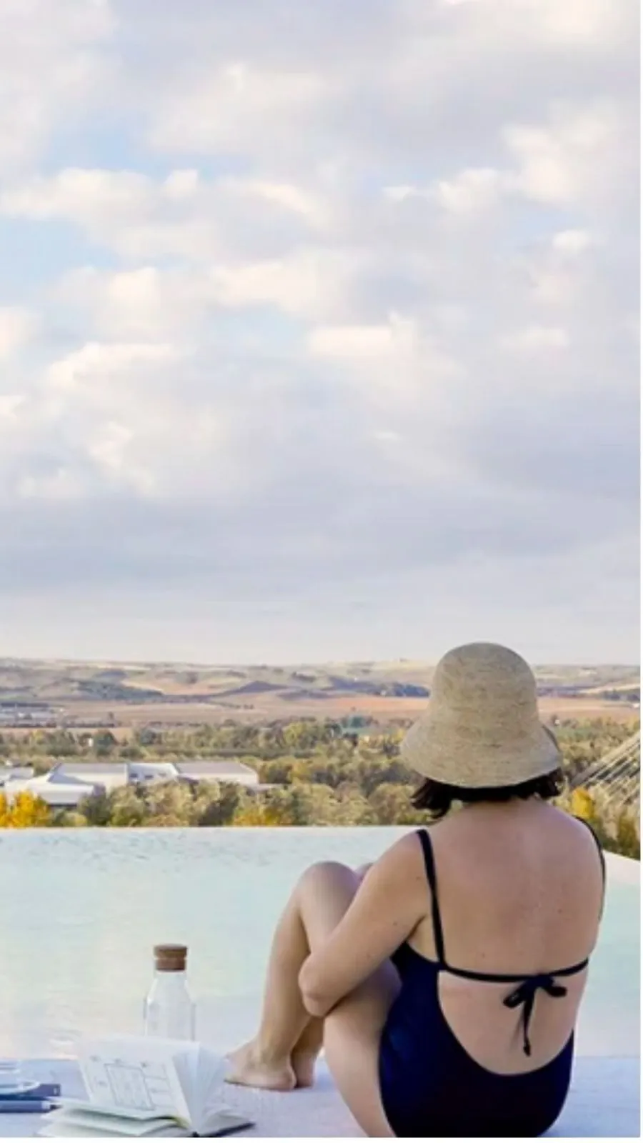 Mujer descansando junto a la piscina con vistas